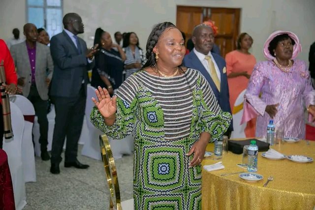 A woman worshipping with raised hand among guests