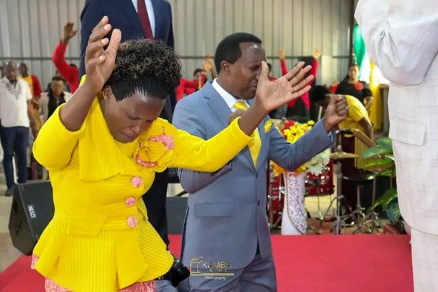A couple kneeling in prayer in a church