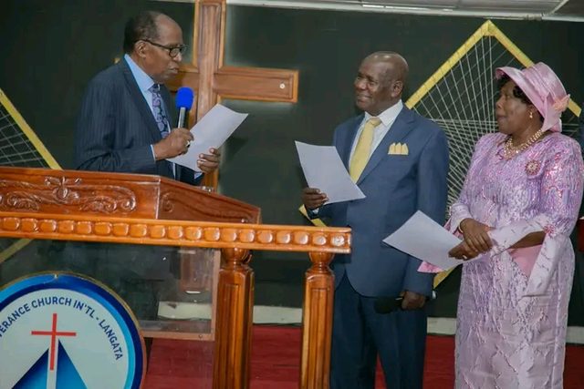 A minister reading at a pulpit beside a couple