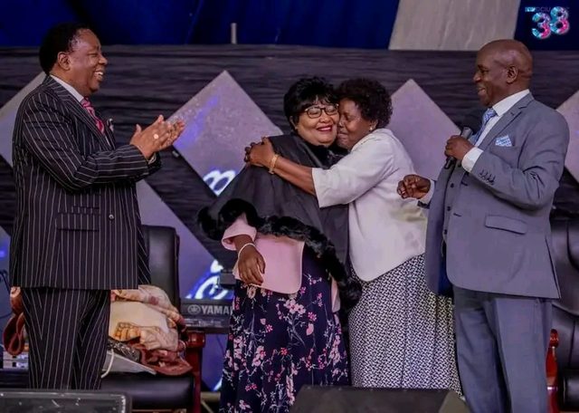 Two bishops laughing as two women embrace