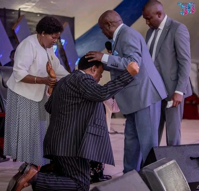 Leaders praying together on stage